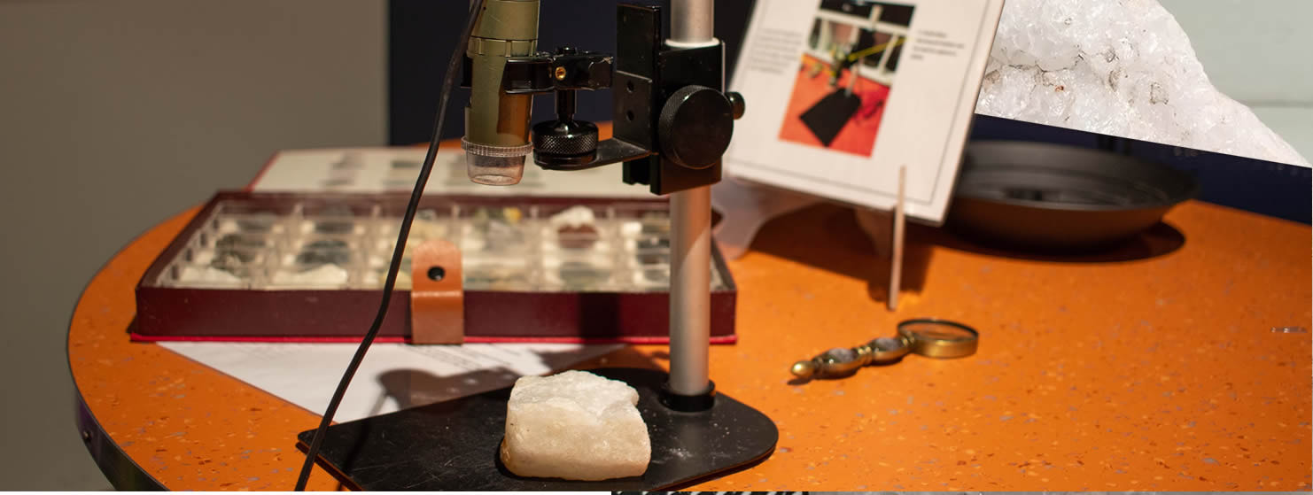 Microscope and geological samples with an overhead projector screen in the Discovery Depot.